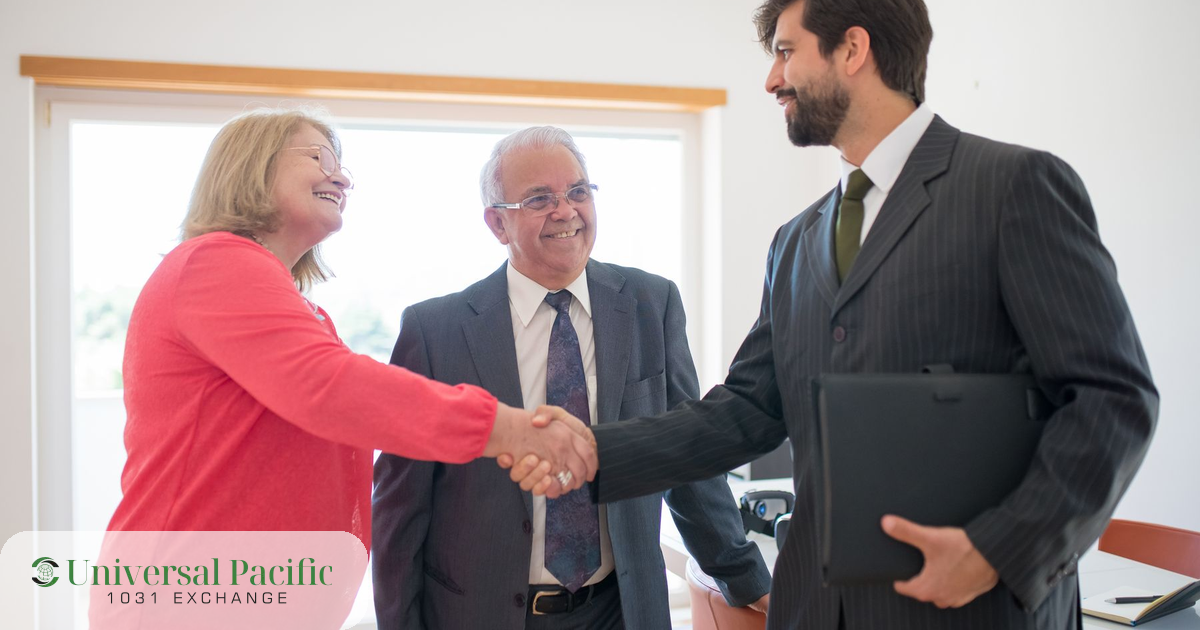 Investors shaking hands with a 1031 exchange advisor in an office, sealing a tax-deferred property exchange agreement.