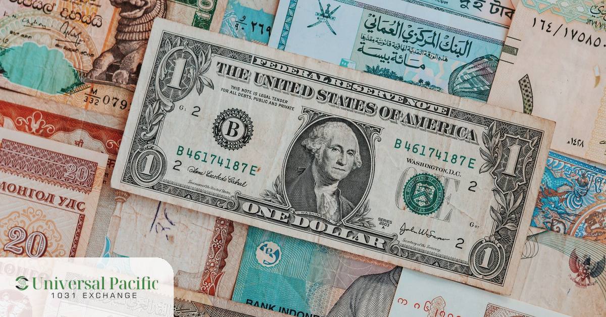 U.S. dollar resting on assorted world currencies, symbolizing cross-border tax challenges in a 1031 exchange